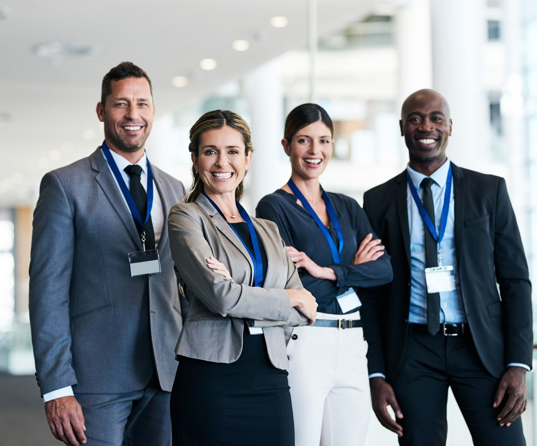 4 business people smile and stand side-by-side